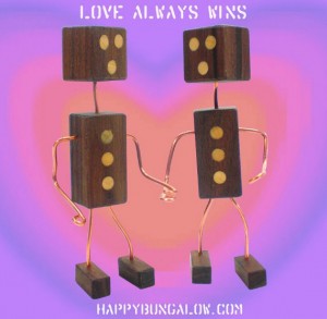 Two handcrafted wood robots holding hands with the caption, LOVE ALWAYS WINS